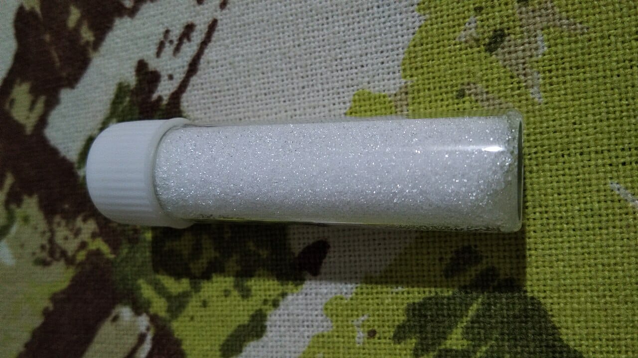 Clear container filled with small white Epsom salt crystals